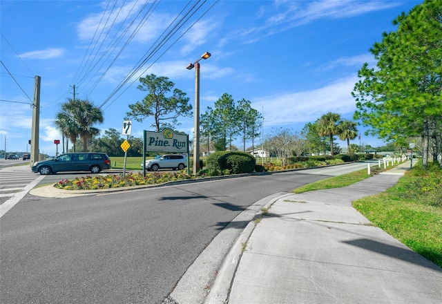 view of road featuring curbs, traffic signs, and sidewalks