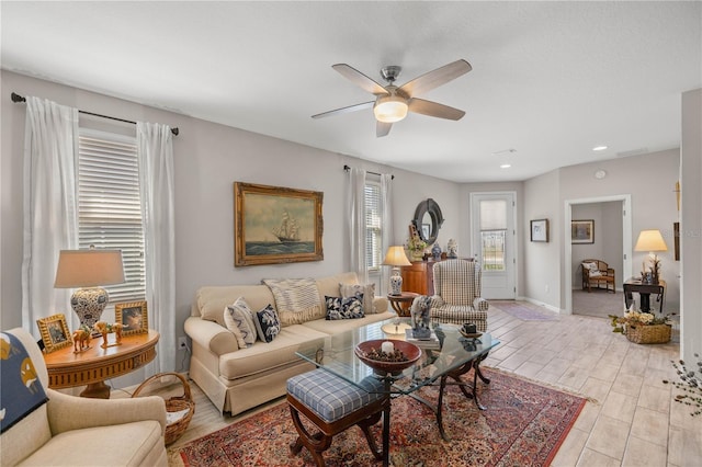 living area with recessed lighting, ceiling fan, light wood-style flooring, and baseboards