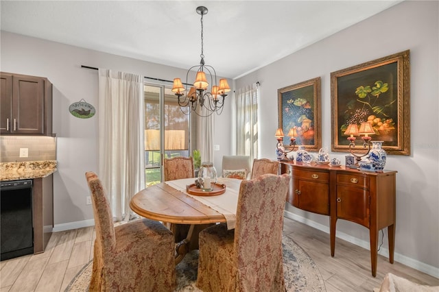 dining room with an inviting chandelier, baseboards, and light wood-style floors