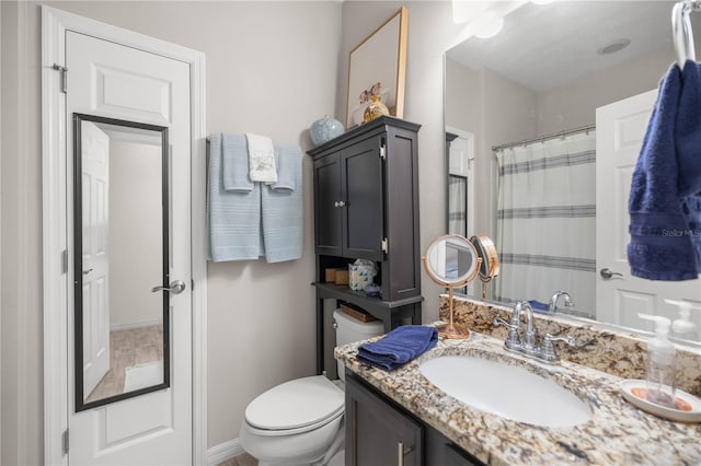 bathroom with toilet, a shower with curtain, and vanity