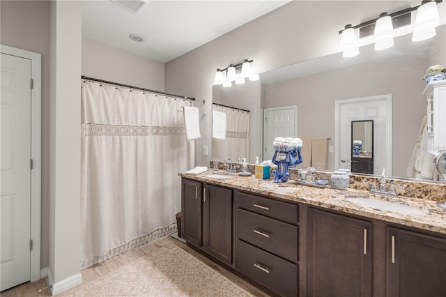 full bathroom featuring a shower with curtain, a sink, and double vanity