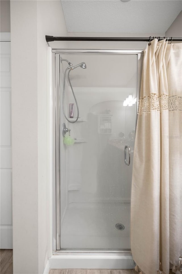 bathroom featuring a stall shower and wood finished floors