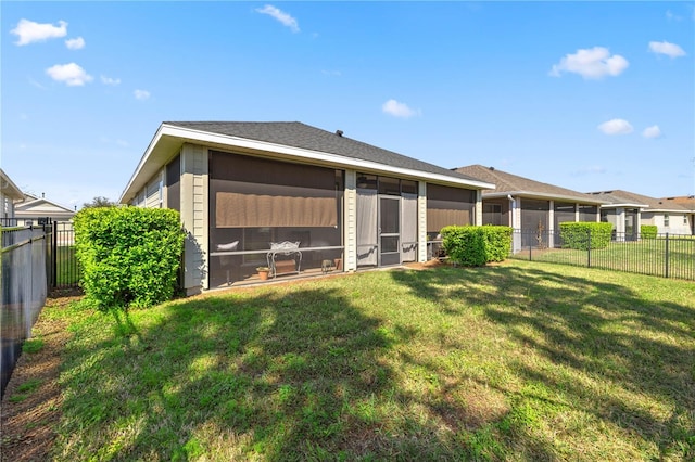 back of house with a yard, a fenced backyard, and a sunroom