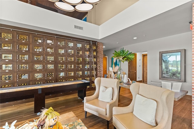 interior space featuring a high ceiling, wood finished floors, and visible vents