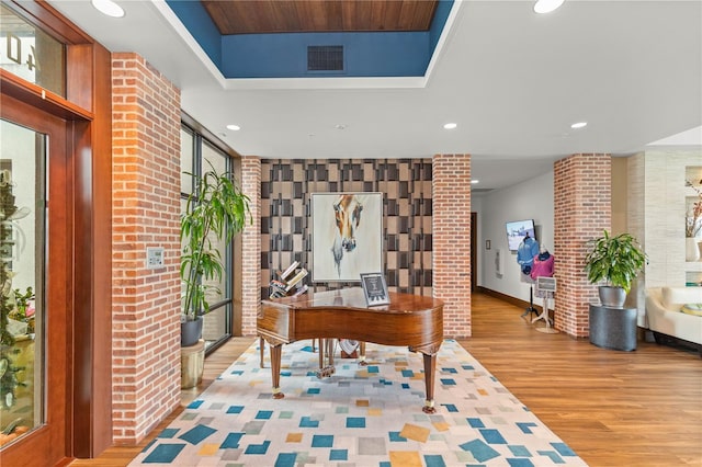 home office featuring baseboards, visible vents, wood finished floors, a tray ceiling, and recessed lighting