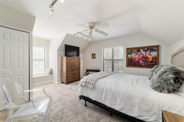 bedroom featuring baseboards, a ceiling fan, lofted ceiling, rail lighting, and carpet floors