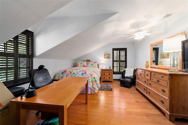 bedroom featuring lofted ceiling, light wood-style floors, and a ceiling fan