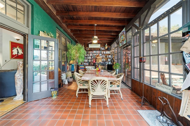 unfurnished sunroom featuring a ceiling fan, a wealth of natural light, beam ceiling, and wooden ceiling