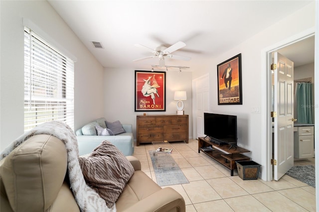 living room featuring a ceiling fan, rail lighting, visible vents, and light tile patterned floors