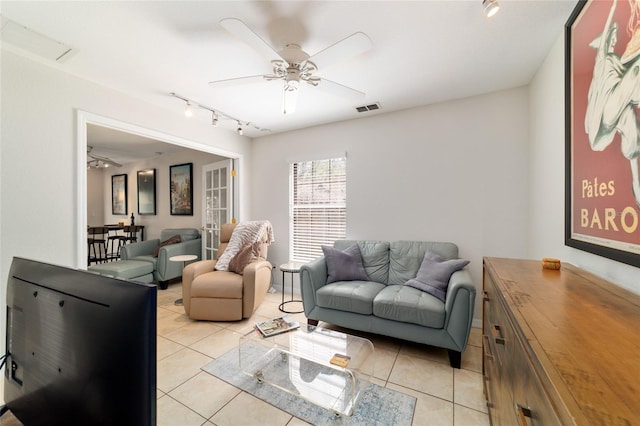 living room with light tile patterned flooring, visible vents, and a ceiling fan