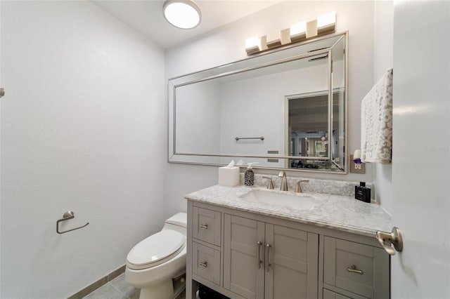 half bath with toilet, tile patterned flooring, baseboards, and vanity