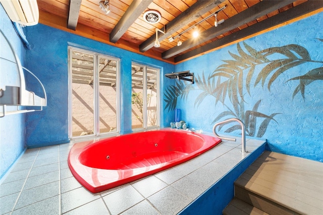 bathroom featuring a tub to relax in, beamed ceiling, rail lighting, and wood ceiling