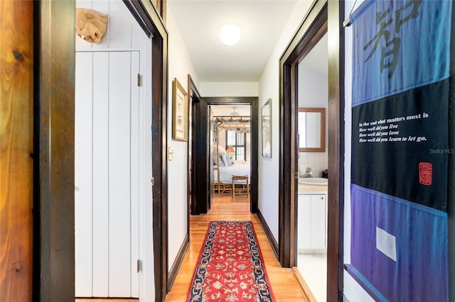 hall with a sink and light wood-style floors