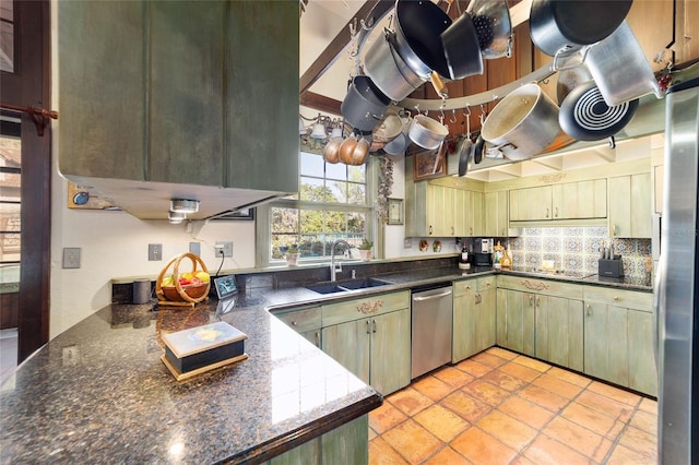 kitchen featuring light tile patterned floors, stainless steel appliances, tasteful backsplash, and a sink