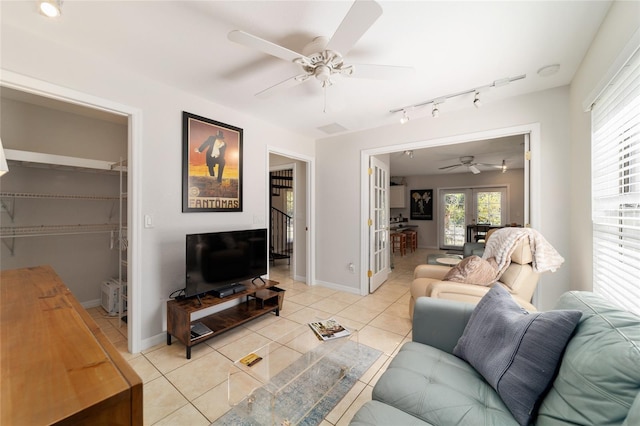 living room featuring light tile patterned floors, ceiling fan, baseboards, and rail lighting