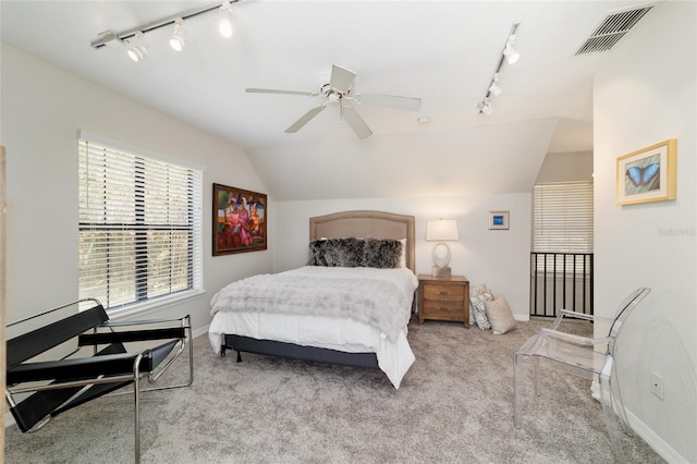 carpeted bedroom featuring lofted ceiling, baseboards, visible vents, and a ceiling fan