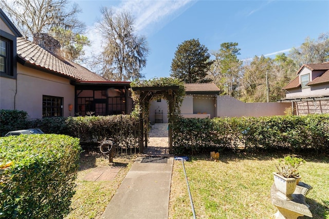 view of front of house featuring a tile roof, a front yard, and stucco siding