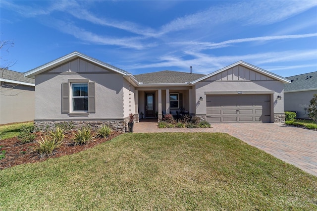 ranch-style house featuring stone siding, decorative driveway, an attached garage, and a front yard