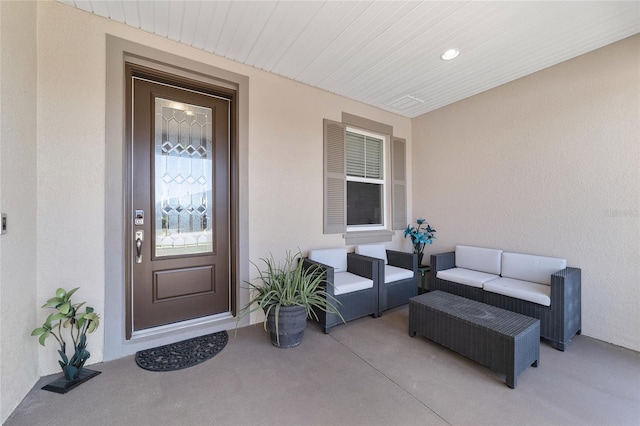 entrance to property featuring an outdoor living space and stucco siding