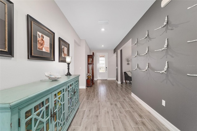 hallway featuring light wood-style floors and baseboards