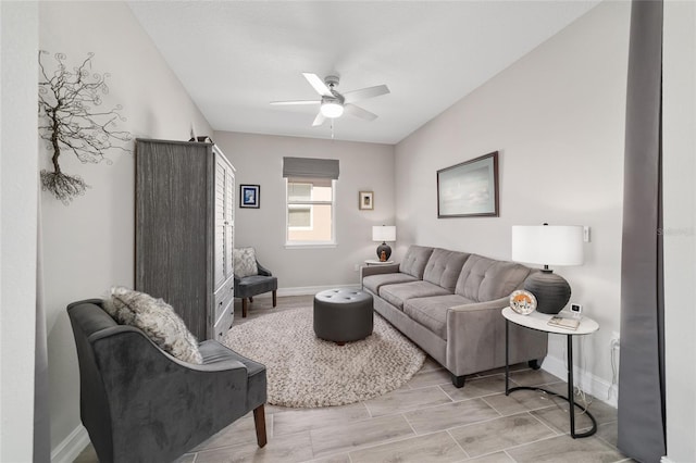 living room with a ceiling fan and baseboards