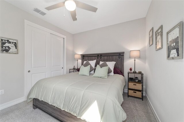 carpeted bedroom with a ceiling fan, a closet, visible vents, and baseboards