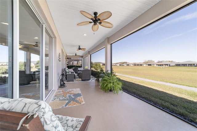 sunroom / solarium featuring a healthy amount of sunlight and ceiling fan