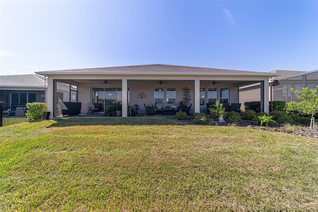 rear view of property featuring ceiling fan, a lawn, a patio area, and stucco siding