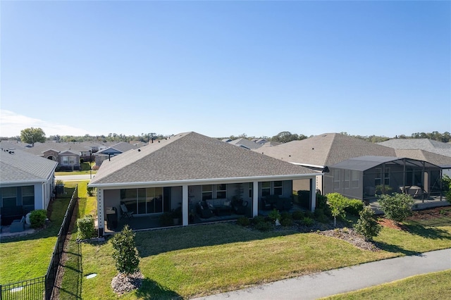 view of front facade with a front lawn, fence, a residential view, and a lanai