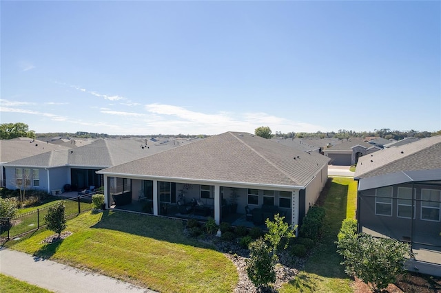 back of property with a fenced backyard, roof with shingles, a lawn, a residential view, and a patio area