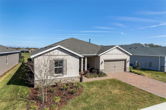 ranch-style house featuring a garage, decorative driveway, board and batten siding, and a front yard