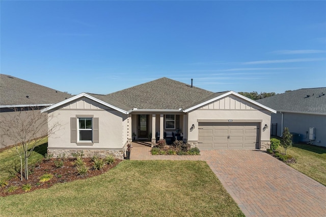 ranch-style home featuring board and batten siding, stone siding, a front lawn, and an attached garage