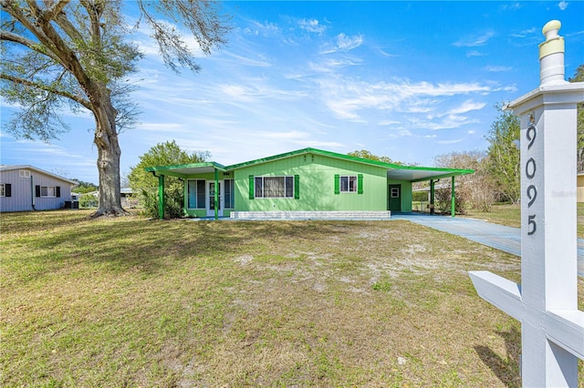 view of front facade featuring a front yard, concrete driveway, and an attached carport