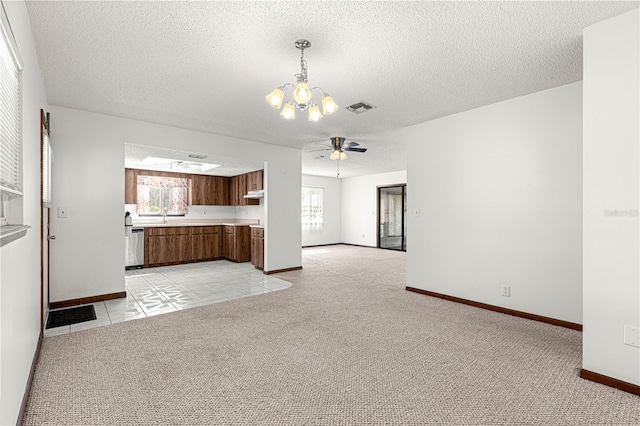 unfurnished living room with light colored carpet, visible vents, baseboards, and ceiling fan with notable chandelier