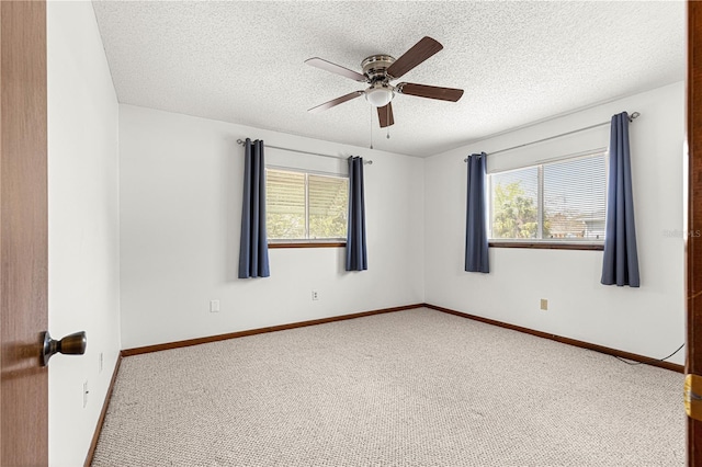 carpeted empty room featuring a ceiling fan, baseboards, and a textured ceiling