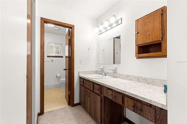 bathroom with visible vents, toilet, tile patterned floors, a textured ceiling, and vanity