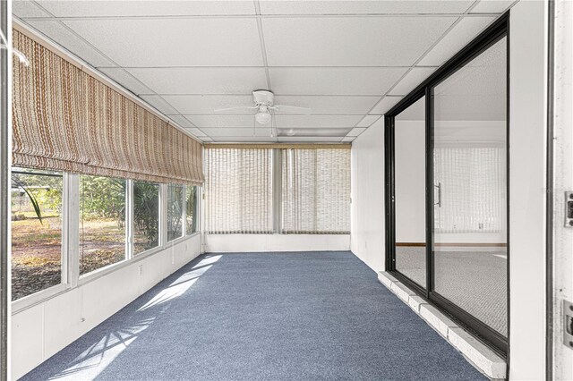 unfurnished sunroom with ceiling fan and a paneled ceiling