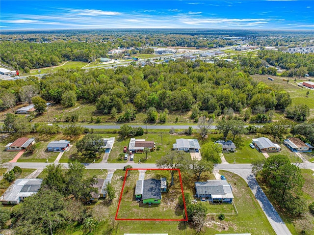 bird's eye view with a wooded view