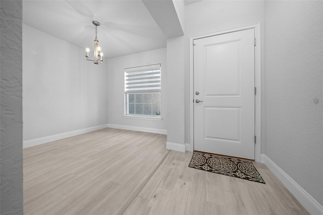 entryway with a notable chandelier, baseboards, and wood finished floors