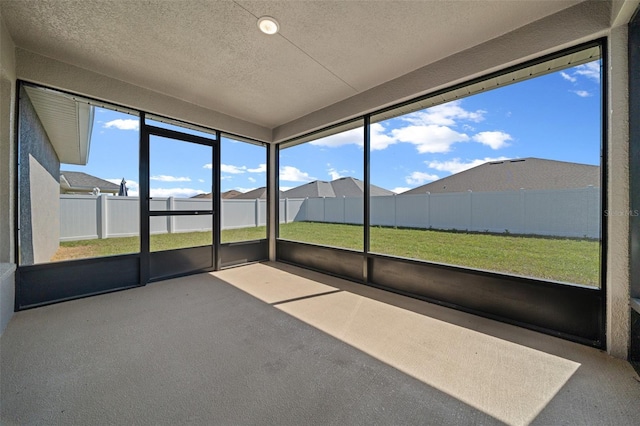 unfurnished sunroom with a residential view and a wealth of natural light