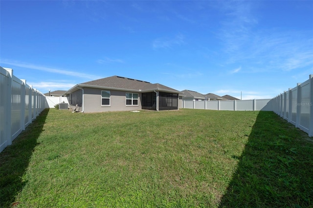 rear view of property with a lawn, cooling unit, a fenced backyard, and a sunroom