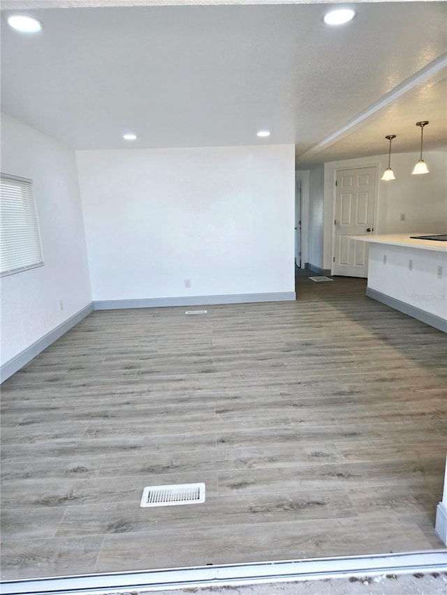 unfurnished living room featuring visible vents, baseboards, wood finished floors, and recessed lighting