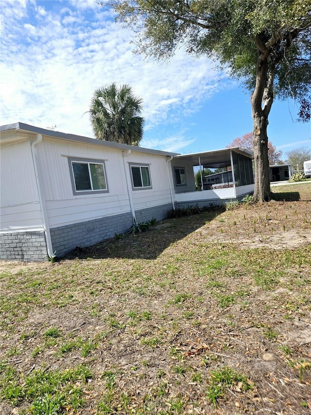 view of property exterior with a sunroom and an attached carport