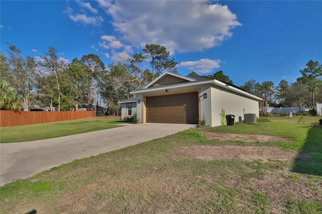 view of home's exterior with a yard, stucco siding, central AC, fence, and driveway