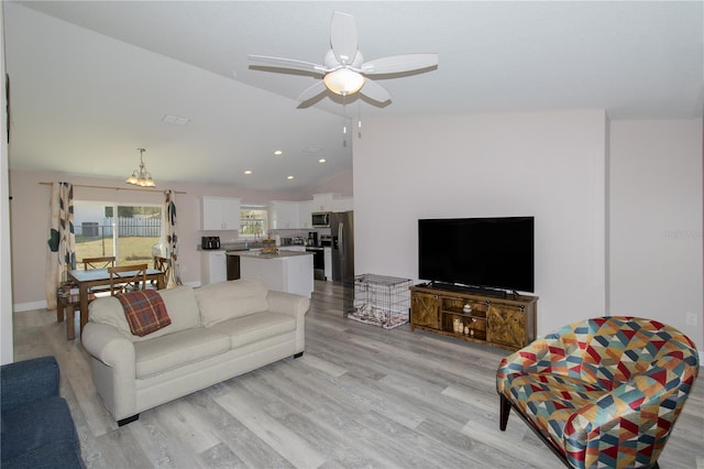 living area featuring light wood-type flooring, a ceiling fan, vaulted ceiling, and recessed lighting