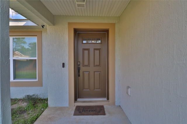 doorway to property featuring stucco siding