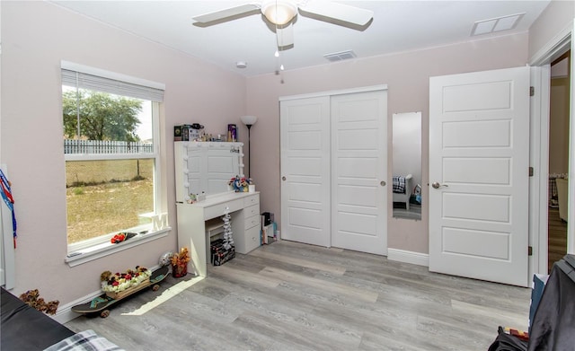 living area featuring baseboards, ceiling fan, visible vents, and wood finished floors