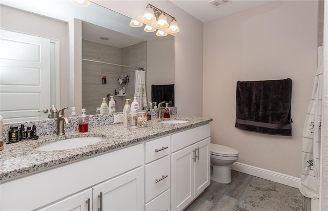 bathroom with visible vents, a sink, wood finished floors, and toilet