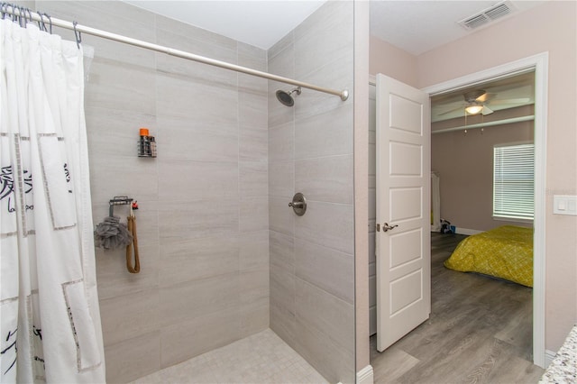 bathroom featuring visible vents, wood finished floors, tiled shower, connected bathroom, and a ceiling fan