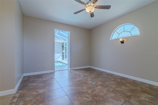 spare room featuring baseboards and a ceiling fan